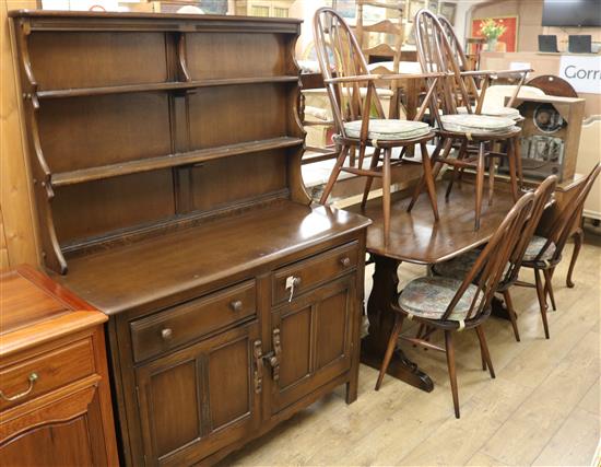 An Ercol dark-stained elm dining suite, comprising table, six chairs and a dresser table W.152cm